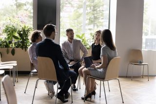 Foto: Personen sitzend im Kreis